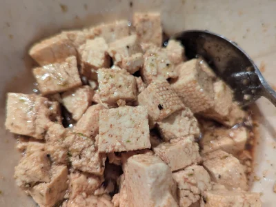 Dans un bol, mélangez un filet d'huile de tournesol avec le miel, les zestes de citron vert et la sauce soja. Ajouter le vinaigre et les cubes de tofu. Poivrez, mélangez et réservez en remuant de temps à autre.