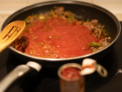 Versez la pulpe de tomate et le concentré de tomates, puis mélangez bien.
