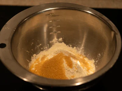 Dans un grand bol, mélangez la farine, le sucre roux, la levure chimique.